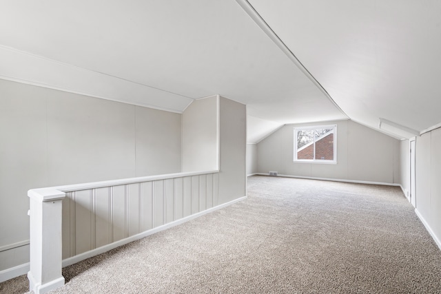 bonus room with lofted ceiling and carpet flooring