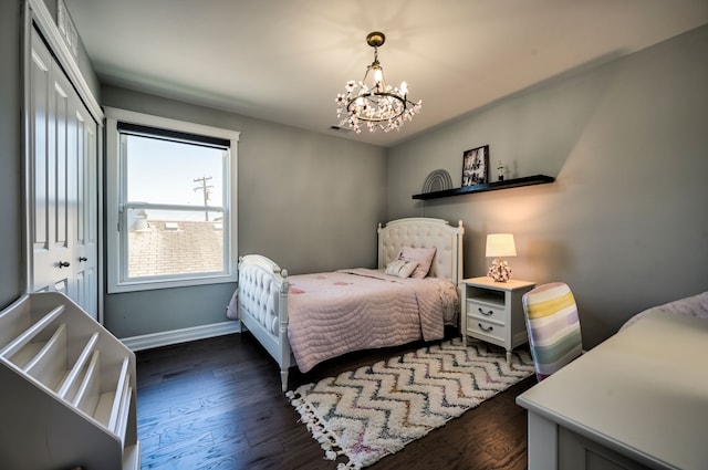 bedroom featuring dark wood-type flooring, a closet, and a chandelier