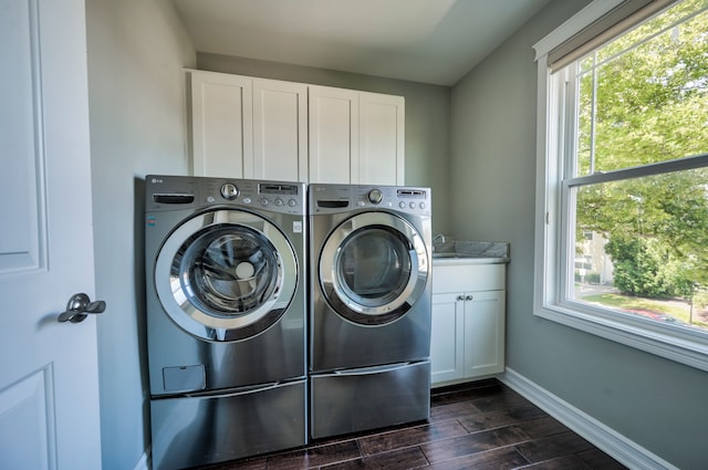 clothes washing area with cabinets, sink, and independent washer and dryer