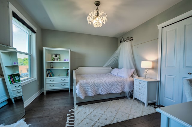 bedroom featuring dark hardwood / wood-style flooring and a notable chandelier