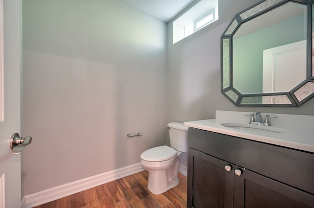 bathroom featuring vanity, wood-type flooring, and toilet