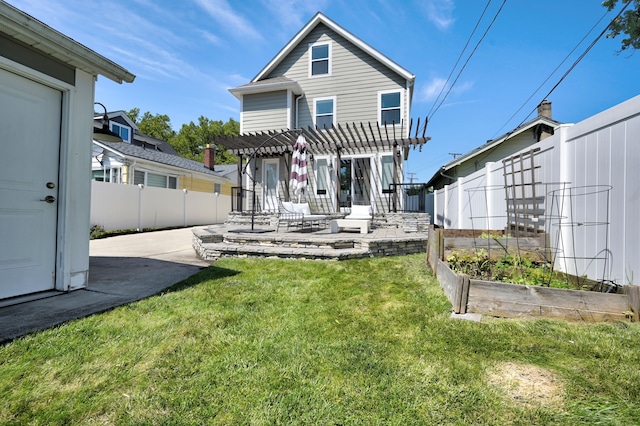 rear view of house with a yard, a pergola, and a patio area