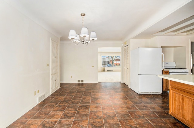 kitchen featuring white appliances, brown cabinetry, visible vents, light countertops, and a notable chandelier