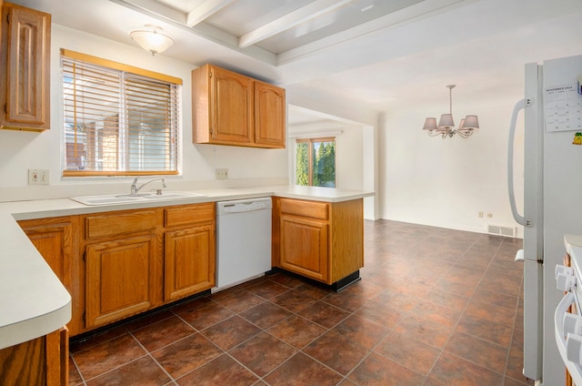 kitchen with visible vents, light countertops, a peninsula, white appliances, and a sink