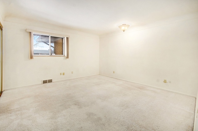 carpeted empty room featuring visible vents