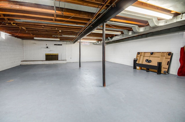 unfinished basement featuring a brick fireplace