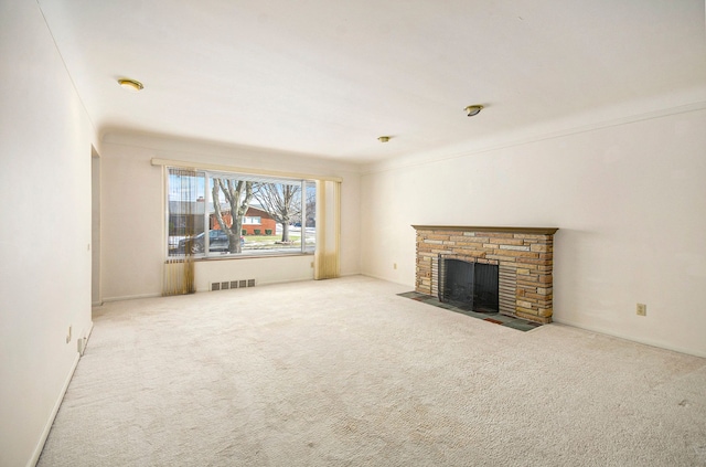 unfurnished living room with visible vents, a fireplace with flush hearth, and carpet floors