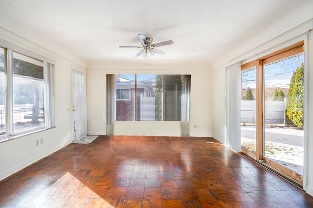 spare room with baseboards and a ceiling fan