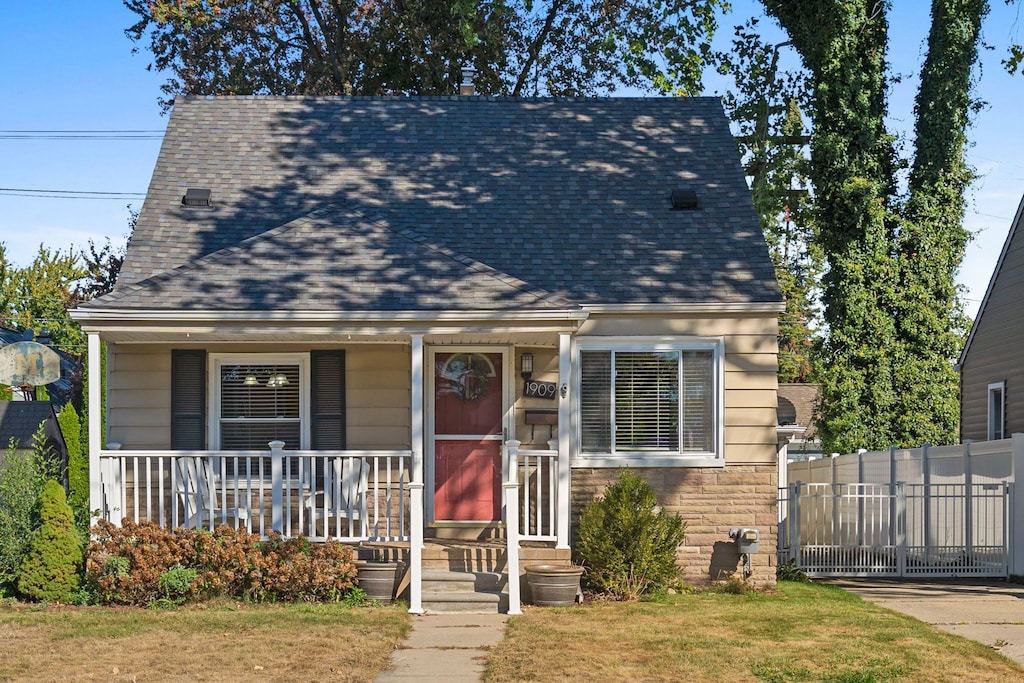 view of front of property with a porch and a front lawn