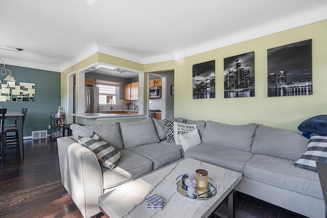 living room with dark hardwood / wood-style flooring and sink