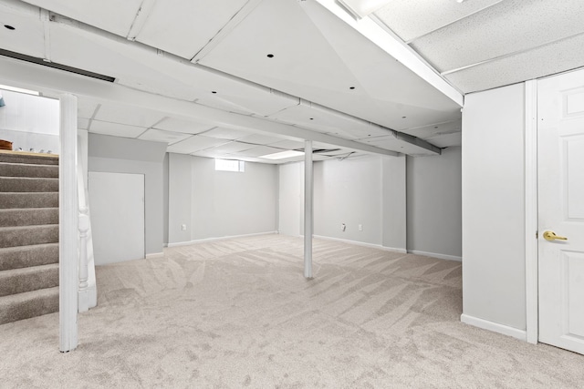 basement featuring carpet and a paneled ceiling