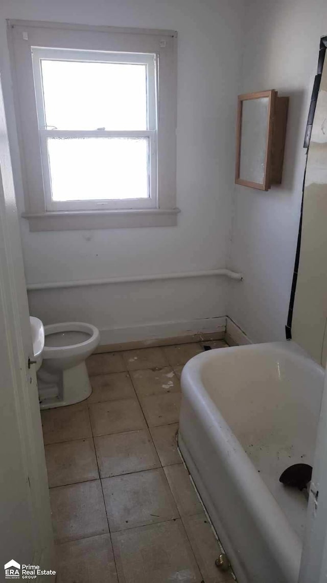 bathroom with a bathtub, tile patterned floors, and toilet