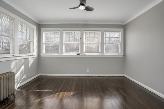 unfurnished sunroom with radiator, plenty of natural light, and ceiling fan