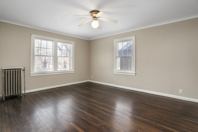 spare room featuring dark hardwood / wood-style flooring, radiator heating unit, and ceiling fan