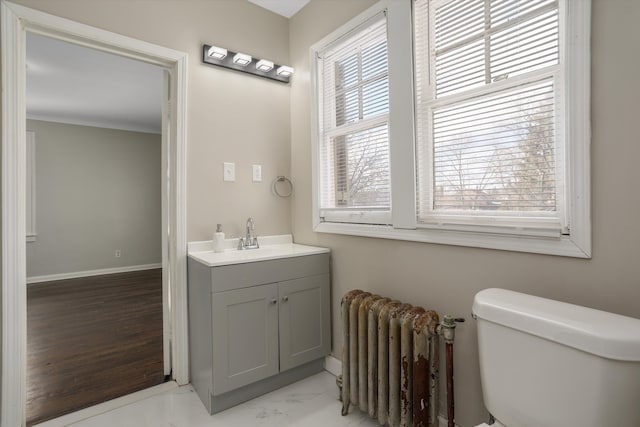 bathroom featuring vanity, radiator heating unit, and toilet