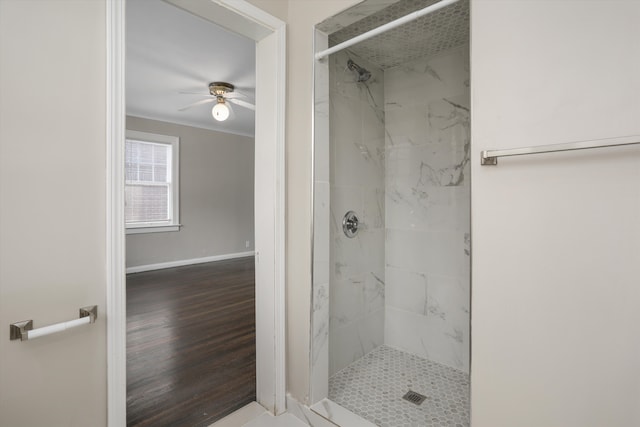 bathroom with ceiling fan, wood-type flooring, and a tile shower