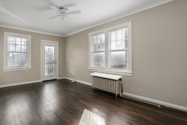 empty room with radiator, dark hardwood / wood-style floors, and ceiling fan