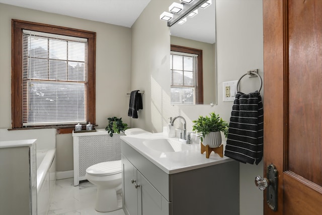 bathroom featuring vanity, a tub, and toilet