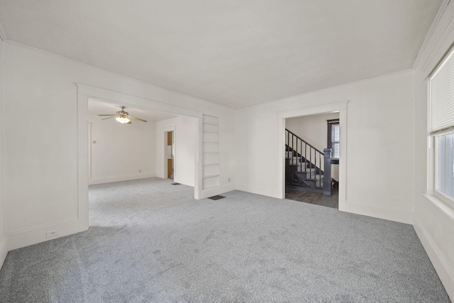 carpeted empty room with built in shelves and a wealth of natural light