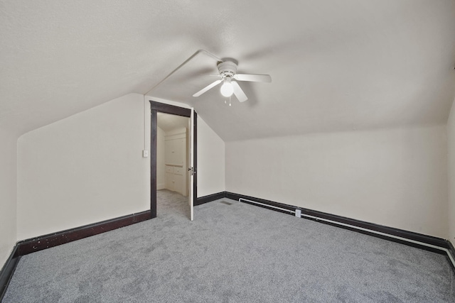 bonus room with vaulted ceiling and light colored carpet