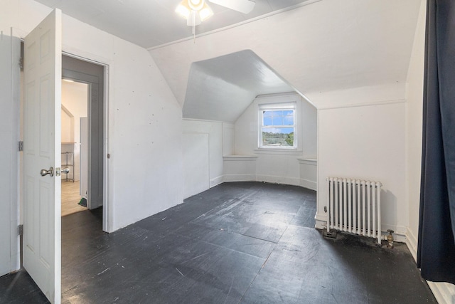 bonus room with vaulted ceiling, radiator heating unit, and ceiling fan