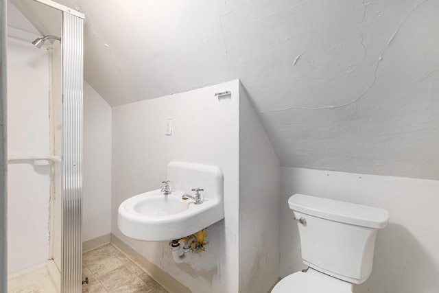 bathroom featuring lofted ceiling, sink, and toilet