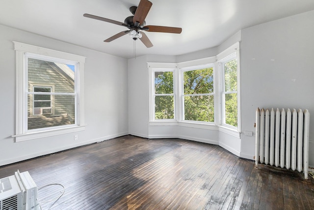 empty room featuring radiator, dark wood-type flooring, and ceiling fan