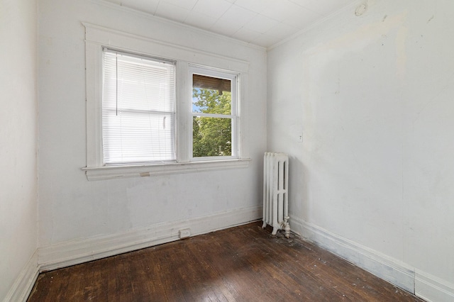 unfurnished room with radiator, crown molding, and dark wood-type flooring