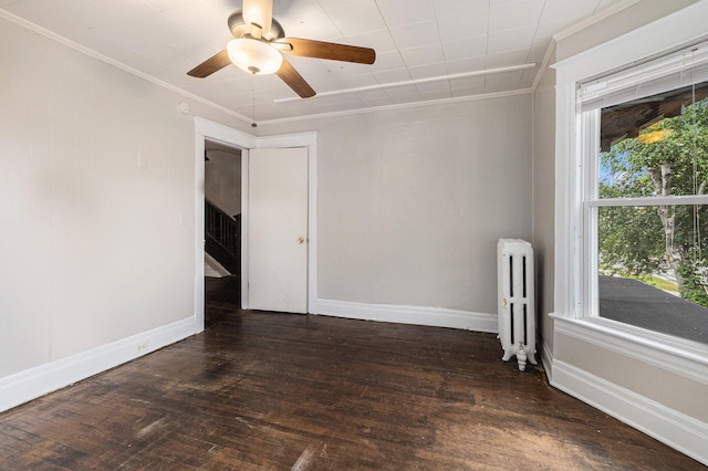 empty room with ceiling fan, ornamental molding, radiator heating unit, and dark hardwood / wood-style floors