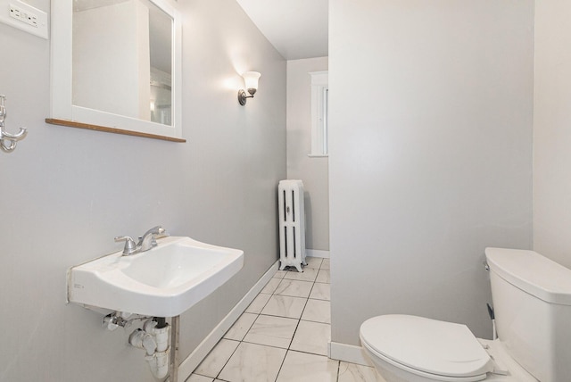 bathroom with radiator heating unit and toilet