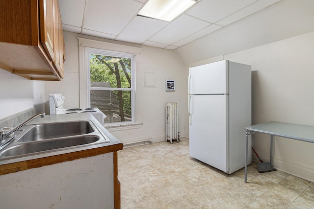 kitchen with sink, a drop ceiling, radiator, and white appliances