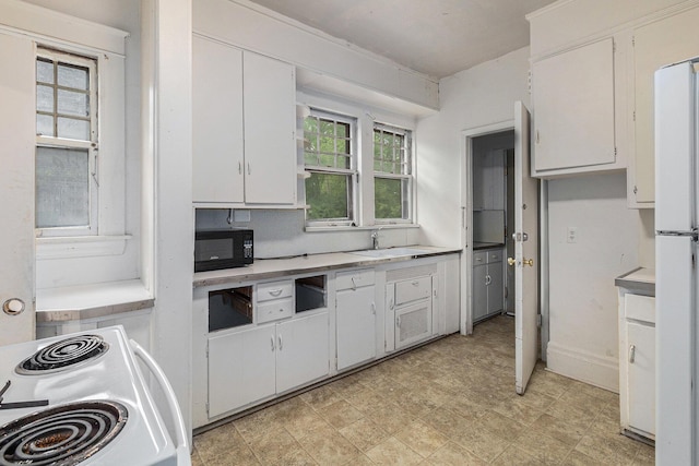 kitchen with white cabinetry, white appliances, and sink