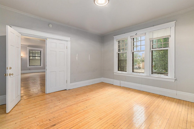 empty room featuring crown molding and light hardwood / wood-style flooring