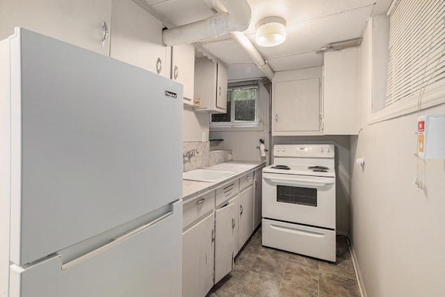 kitchen with sink, white appliances, and white cabinets