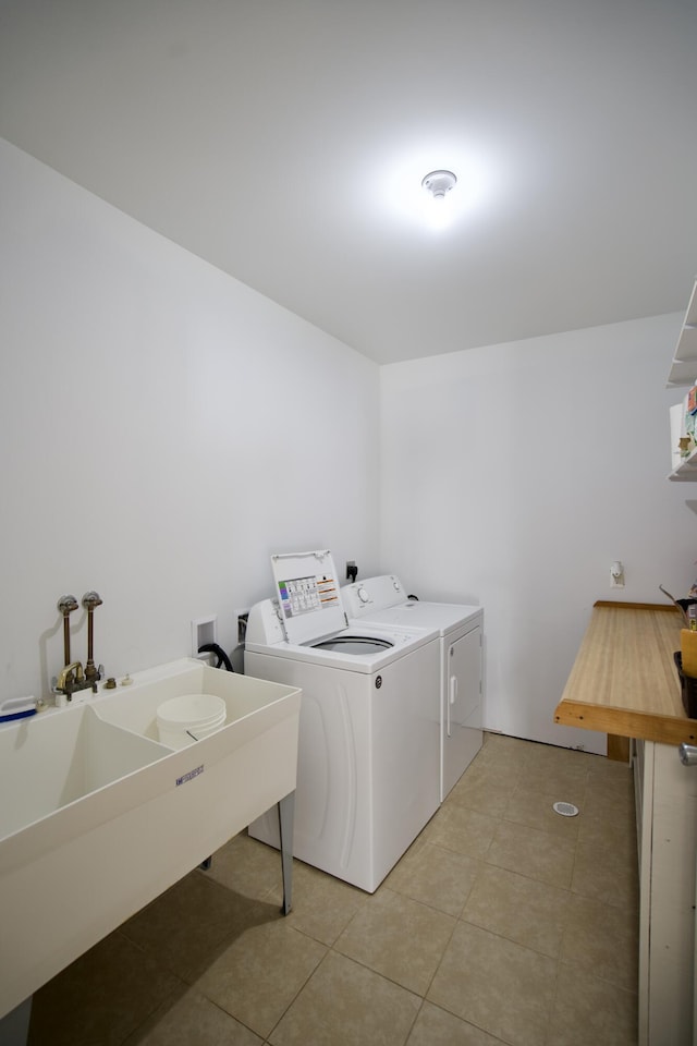 washroom featuring light tile patterned flooring, separate washer and dryer, and sink