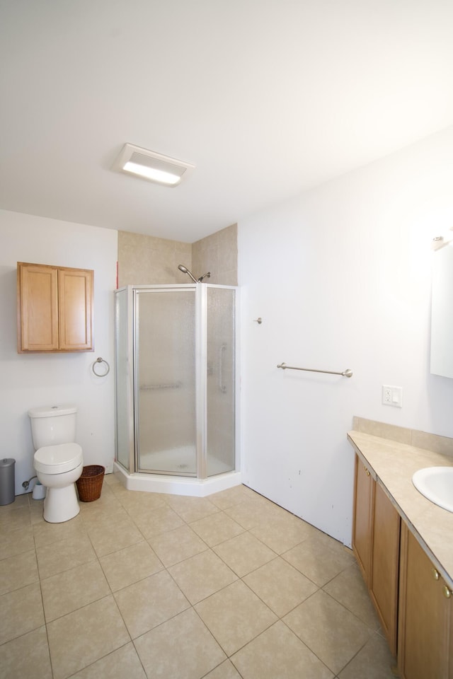 bathroom featuring tile patterned floors, vanity, toilet, and a shower with door