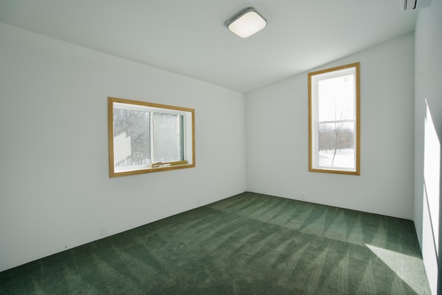 carpeted empty room featuring vaulted ceiling