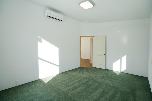 spare room featuring dark carpet and an AC wall unit