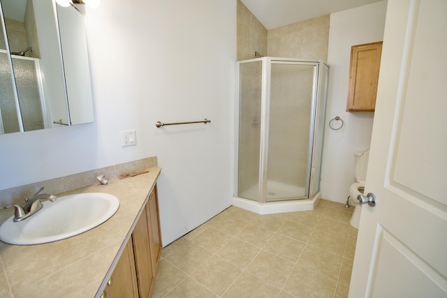 bathroom featuring tile patterned flooring, vanity, toilet, and walk in shower