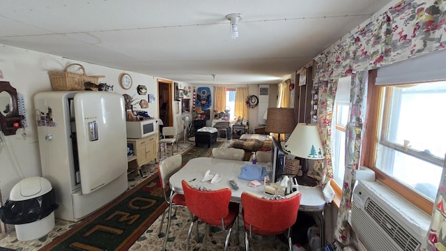 dining room featuring plenty of natural light and a wall unit AC