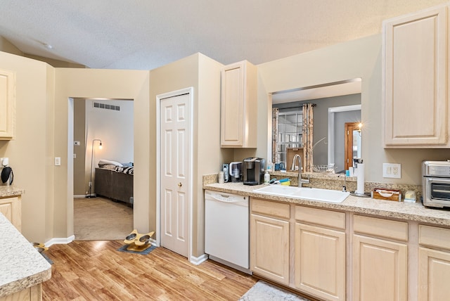 kitchen featuring white dishwasher, sink, light hardwood / wood-style floors, and a textured ceiling