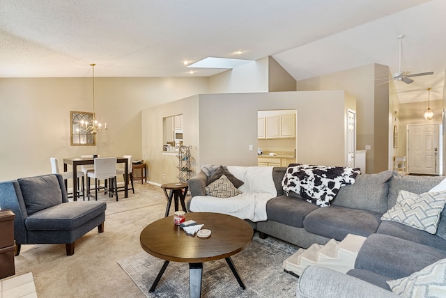 living room featuring vaulted ceiling, ceiling fan with notable chandelier, and light colored carpet