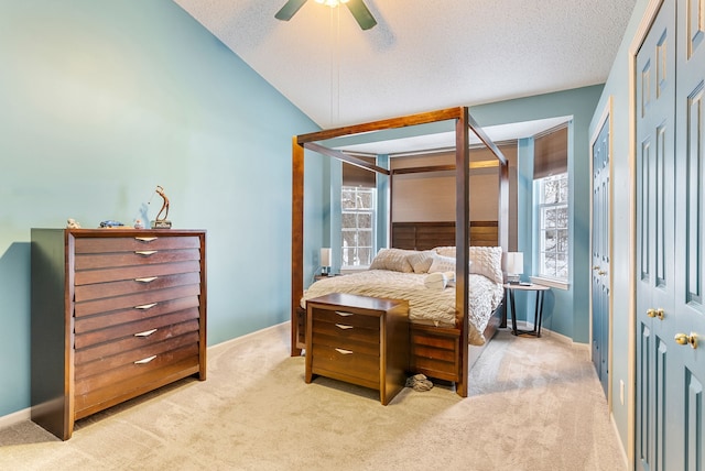 carpeted bedroom featuring ceiling fan, vaulted ceiling, and a textured ceiling