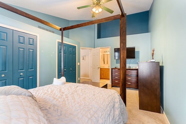 carpeted bedroom with lofted ceiling, two closets, and ensuite bathroom