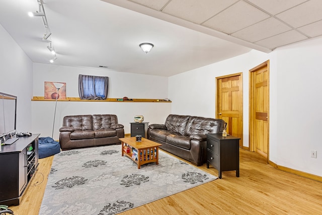 living room featuring a paneled ceiling, wood-type flooring, and rail lighting