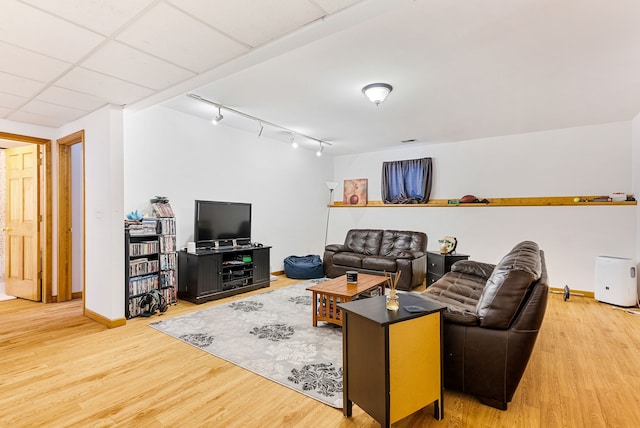 living room with rail lighting, hardwood / wood-style floors, and a drop ceiling