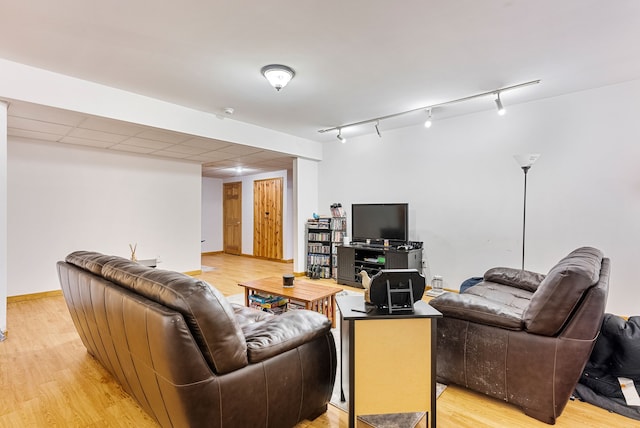 living room featuring rail lighting and light hardwood / wood-style floors