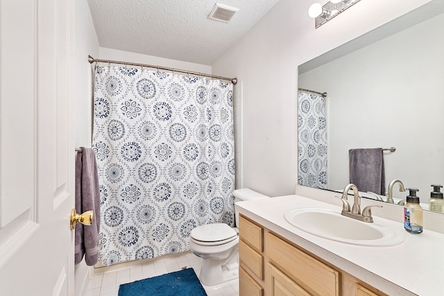 bathroom featuring vanity, tile patterned floors, toilet, and a textured ceiling