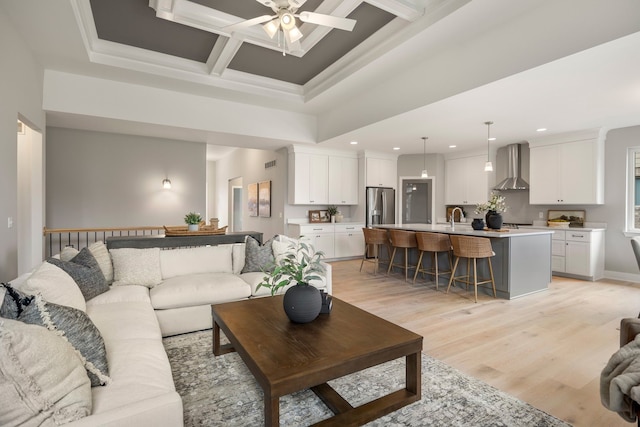 living room with ceiling fan, coffered ceiling, sink, and light wood-type flooring