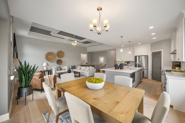 dining area featuring coffered ceiling, sink, light hardwood / wood-style floors, beam ceiling, and ceiling fan with notable chandelier